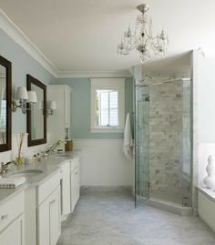 a bathroom with two sinks and a walk in shower next to a bathtub under a window