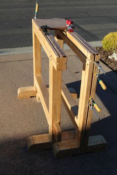 a wooden bench sitting on the side of a road next to a parking lot with tools