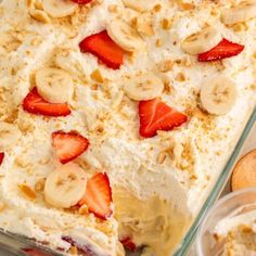 a dessert dish with strawberries and bananas on top, in a glass casserole dish