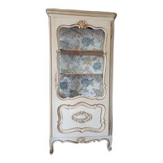 an antique white cabinet with blue flowers on it