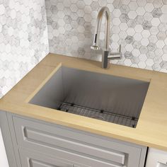 a kitchen sink sitting under a faucet on top of a wooden countertop