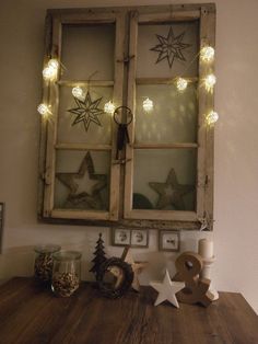 an old window is decorated with stars and lights for the christmas decorations on the table