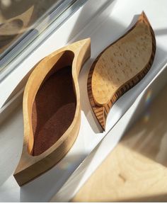 two wooden spoons sitting next to each other on top of a window sill