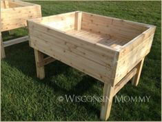 two wooden planters sitting in the grass