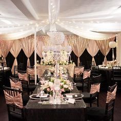 a dining room set up with chandelier and table cloths for an event