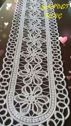 a white table runner with hearts and confetti in the background for valentine's day