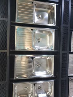 several stainless steel sinks are lined up against the wall in this room with black walls