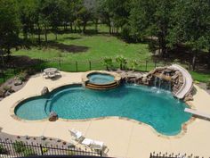 an aerial view of a swimming pool with waterfall