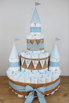 a diaper cake made to look like a castle with blue and white decorations on top