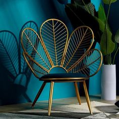 a gold chair with a black cushion and some green plants