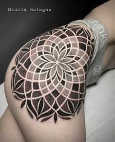 a woman's thigh with a black and white tattoo on it