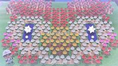 a large group of people standing in front of each other with flowers on the ground