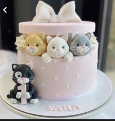 a pink cake decorated with cats and kittens