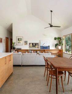 a large open living room and dining area with wood furniture in the middle of it