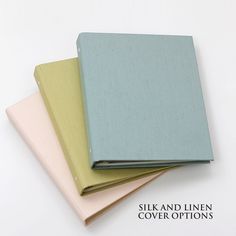 three different colored notebooks sitting next to each other on a white surface with the title silk and linen cover options