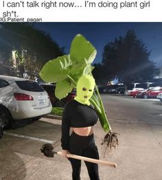 a woman with a green plant on her head holding a baseball bat and wearing a mask