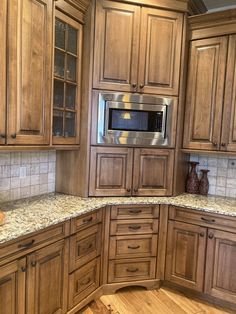 a kitchen with wooden cabinets and granite counter tops in the middle of the flooring