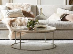 a living room with a couch, table and pillows on the floor in front of it