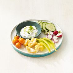 a white plate topped with different types of vegetables and dip on top of each other