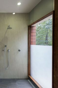 a bathroom with a walk in shower next to a window