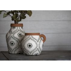 two white and brown vases with plants in them