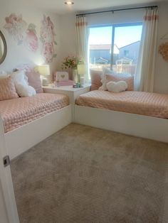 two twin beds in a bedroom with pink and white decor