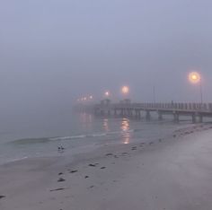 a foggy day at the beach with lights on