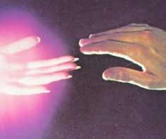 two hands touching each other on a table with light coming from the top and bottom