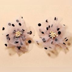 two black and white polka dot hair clips with flowers on them, sitting next to each other