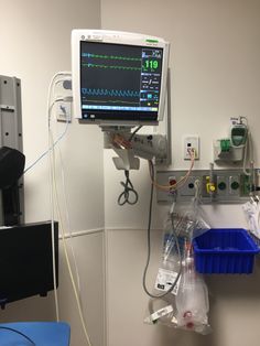 an operating room with medical equipment and monitors on the wall, including wires in plastic containers