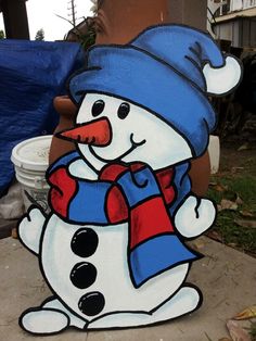 a snowman with a blue hat and scarf on it's head standing next to a fire hydrant