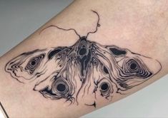 a close up of a person's leg with a butterfly tattoo on the arm