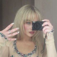 a woman taking a selfie in front of a mirror with her hand on the camera