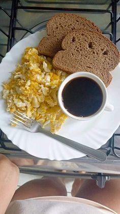 the breakfast is ready to be eaten on the plate, with coffee and toast in front of it