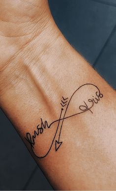 a wrist tattoo with the word love and an arrow in cursive writing on it