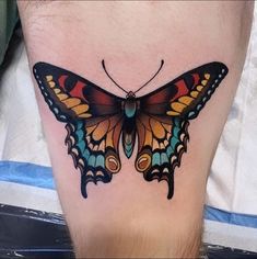 a colorful butterfly tattoo on the leg