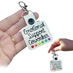 someone is holding a keychain with the words emotion support and love on it