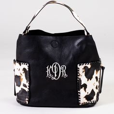 Who doesn't love cow print?! This baby is not only beautiful, but it's roomy too! Featuring two large exterior pockets, this bag has all the space you need for a day out. 11.5"h x 16"w, snap closure Black Hobo Bag With Pockets For Errands, Rectangular Cow Print Travel Bag, Trendy Cow Print Bags For Everyday Use, Black Bag With Cow Print For Everyday Use, Black Hobo Bag With Snap Closure For Travel, Black Rectangular Hobo Bag With Snap Closure, Casual Everyday Bag With Cow Print, Brown Cow Print Bag For Everyday Use, Casual Cow Print Bags For Daily Use