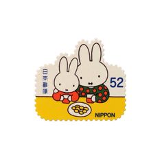 two white rabbits sitting on top of each other next to a plate with food in it