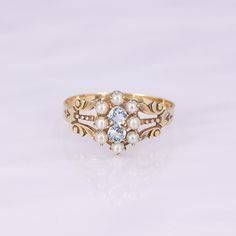 What a remarkable ring! This antique 9-10K gold carved ring features 8 seed pearls and 2 modern replacement round aquamarines. It is lightweight, so not recommended for daily wear. Save her for special occasions to elevate your look!   This antique ring is in good wearable condition, it does show some normal wear, and old marks inside the ring of a trefoil and a W. It comes in a size 8, but it can be sized up or down for you! Custom Wedding Band, Carved Ring, Buy Jewellery Online, Antique Ring, Aqua Marine, Pearl Set, We Fall In Love, Seed Pearl, Save Her