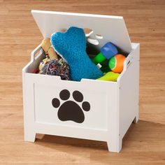 a white toy box filled with toys on top of a wooden floor