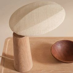 a wooden bowl sitting on top of a table next to a white and brown object