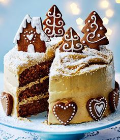 a slice of cake with frosting and decorated gingerbreads on top is sitting on a plate