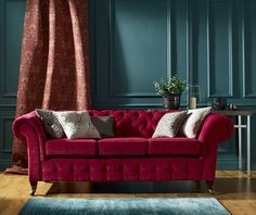 a red couch sitting in front of a blue wall