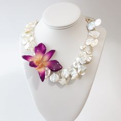 Looking for something unique and luxurious for your wedding day? Our Calypso Keshi Pearl and Real Orchid necklace is perfect for brides who want a touch of elegance and class. This delicate necklace features AAA quality keshi pearls and a real orchid pendant. It's part of our limited edition bridal collection and would be perfect for beach or destination weddings. Whether you're the bride or a wedding guest, this necklace is sure to make a statement. Details: Materials: AAA Keshi Pearls, Topaz a Elegant Orchid Flower Jewelry, Delicate Mother Of Pearl Jewelry For Wedding, Pearl Flower Necklace For Wedding, Wedding Pearl Drop Necklace In Mother Of Pearl, Delicate Mother Of Pearl Necklace For Wedding, Flower-shaped Pearl Jewelry For Wedding, Pearl Flower Jewelry For Wedding, Flower Shaped Pearl Jewelry For Weddings, Flower Shaped Pearl Necklace For Weddings