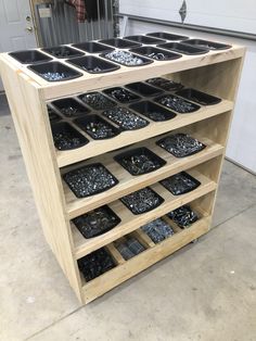 a wooden shelf filled with lots of black trays