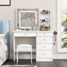 a bedroom with a bed, desk and mirror on it's wall next to a window