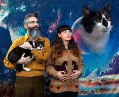 two people standing in front of a backdrop with a cat and an image of the earth