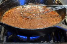 a frying pan filled with food cooking on top of a stove