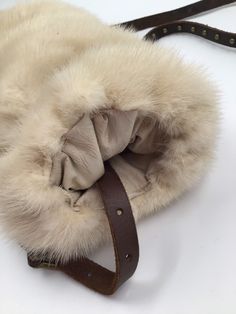 "Light beige women's muff, made from real mink fur, soft and velvet fur with long pile, comfort muff, warm muff, cinema style muff, Red carpet muff, wedding muff, party muff, bride muff, theatre muff, show muff, vintage style, retro style, has size medium. Women's fashionable muff; made from real mink fur; fur is soft and genuine, with shiny long pile; warm, broad, comfortable muff - light beige color. Fashionable muff, perfectly representing the function of warming and decoration; has leather b Mink Sheepskin Fur Coat With Faux Fur Lining, Mink Colored Sheepskin Fur Coat With Faux Fur Lining, Mink Color Sheepskin Fur Coat With Faux Fur Lining, Cream Sheepskin Fur Coat With Faux Fur Trim, Cream Fur Coat With Faux Fur Lining, Cream Faux Fur Coat With Faux Fur Lining, Fluffy Beige Faux Fur Coat, Cream Faux Fur Coat, Cowboy Jacket